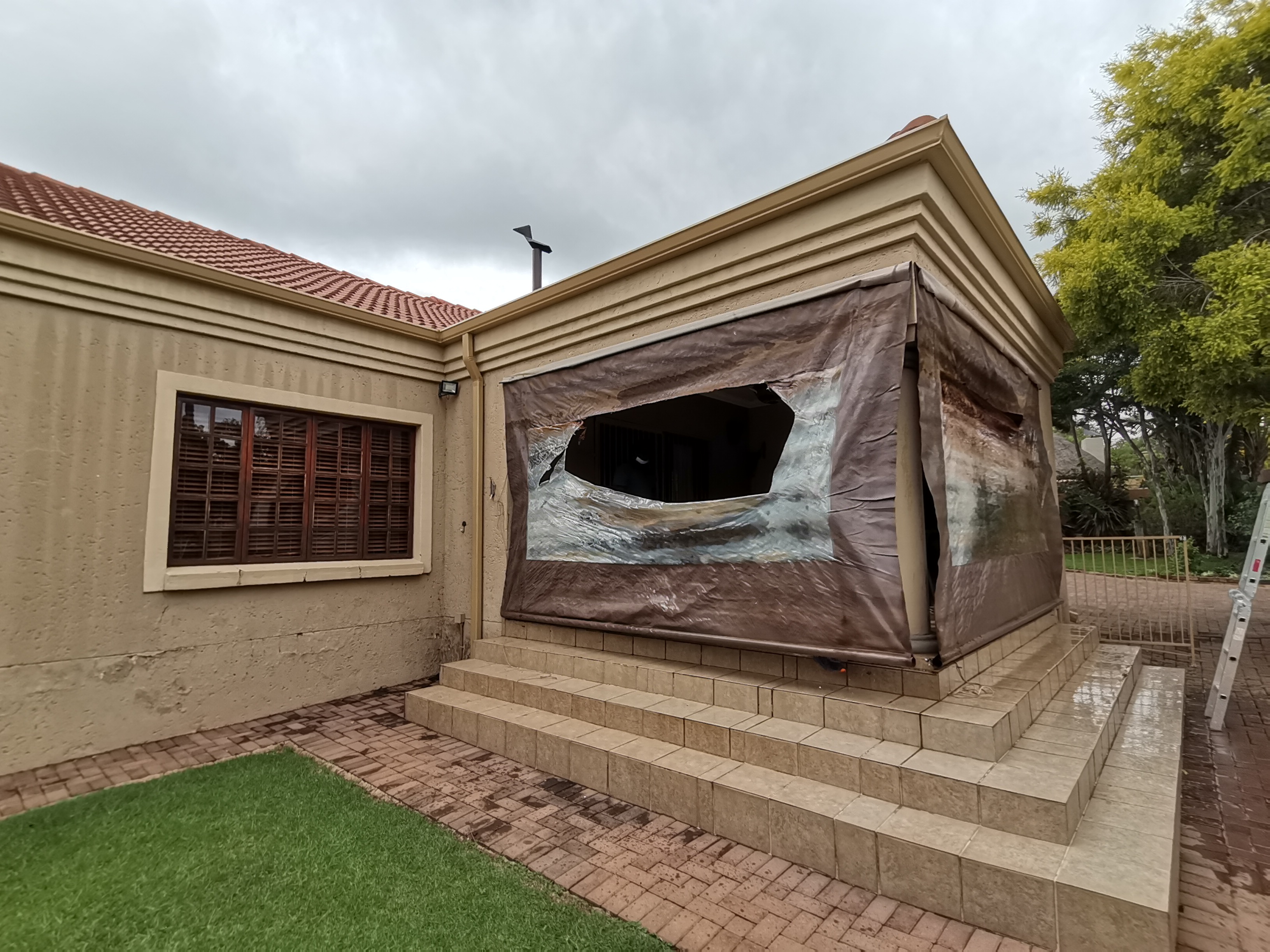 Old torn PVC patio enclosure before replacement